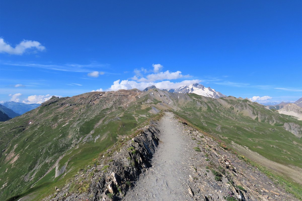 An Alpine ridge trail leading toward the snow-capped Mont Blanc massif